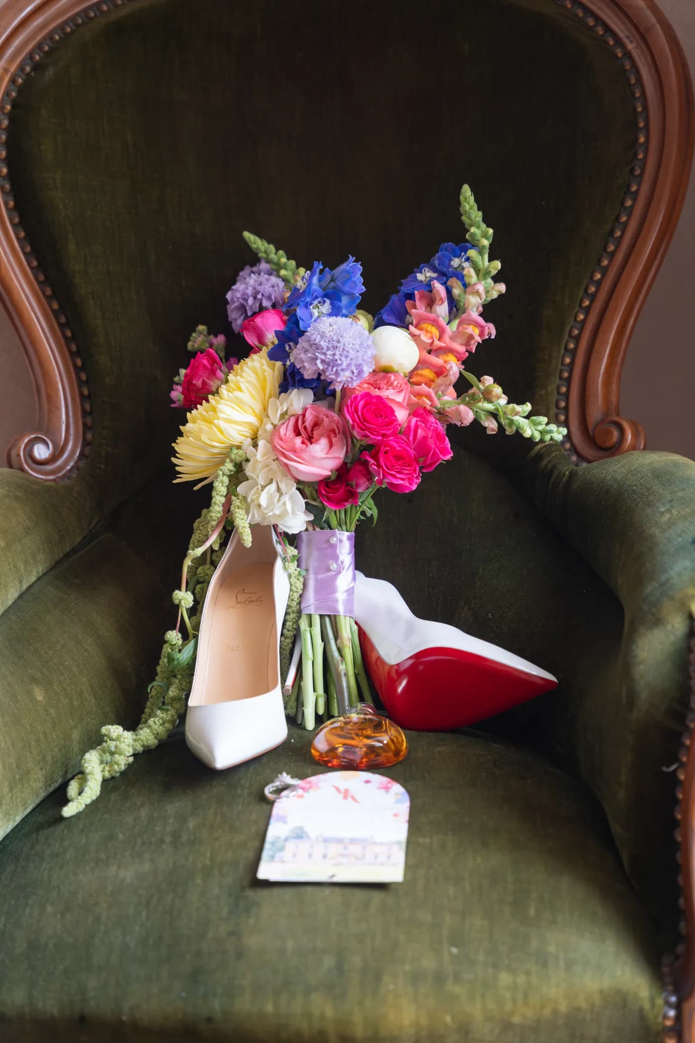 Bouquet de la mariée et escarpins posés sur un fauteuil en velours vert